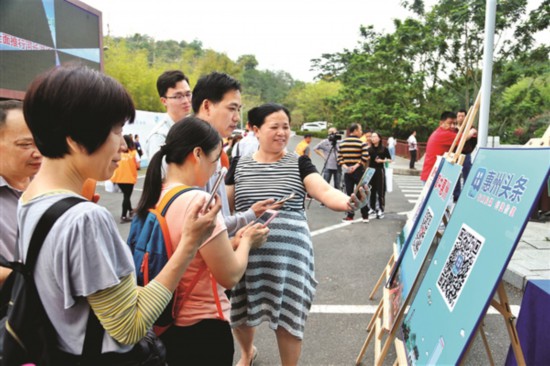     活动现场市民扫描二维码下载“惠州头条”APP。